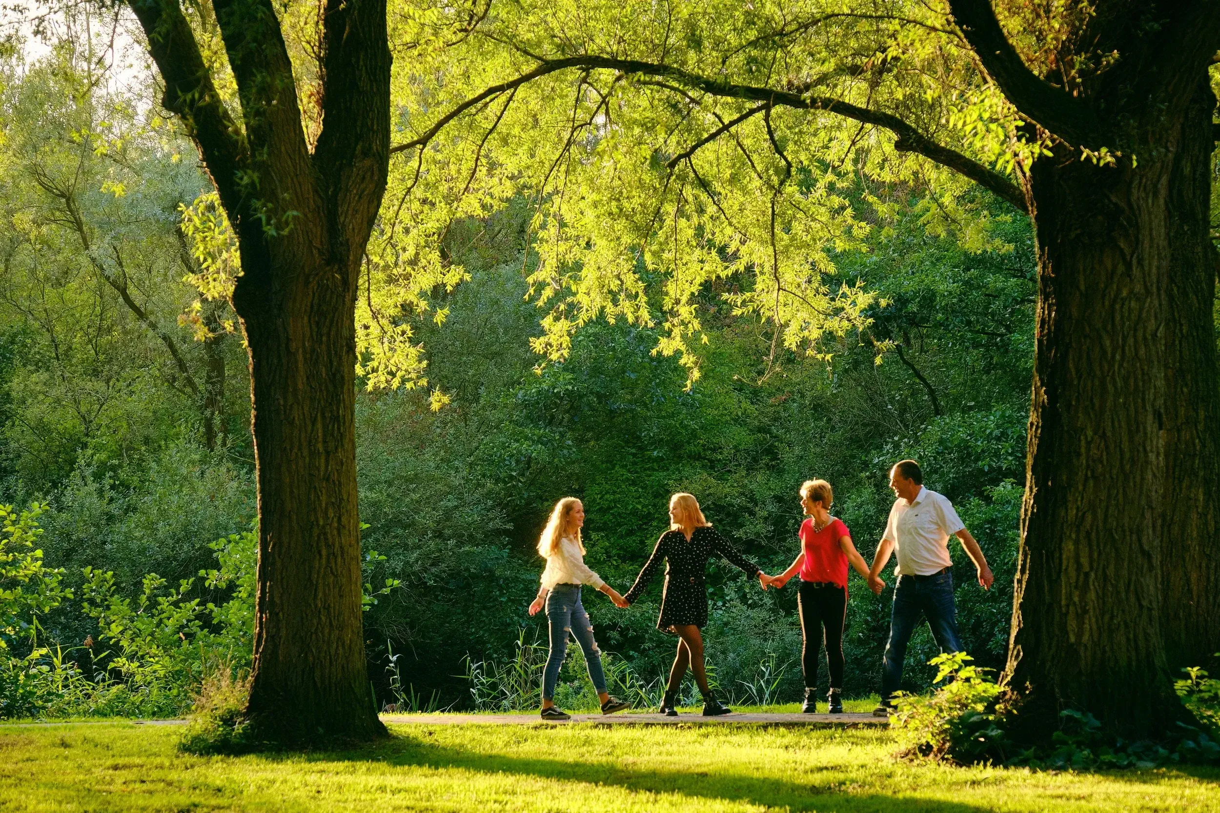 Een gezinsfotoshoot in het park tijdens golden hour. Deze fotoshoot is in september rond 19.00 uur in de avond gefotografeerd.
